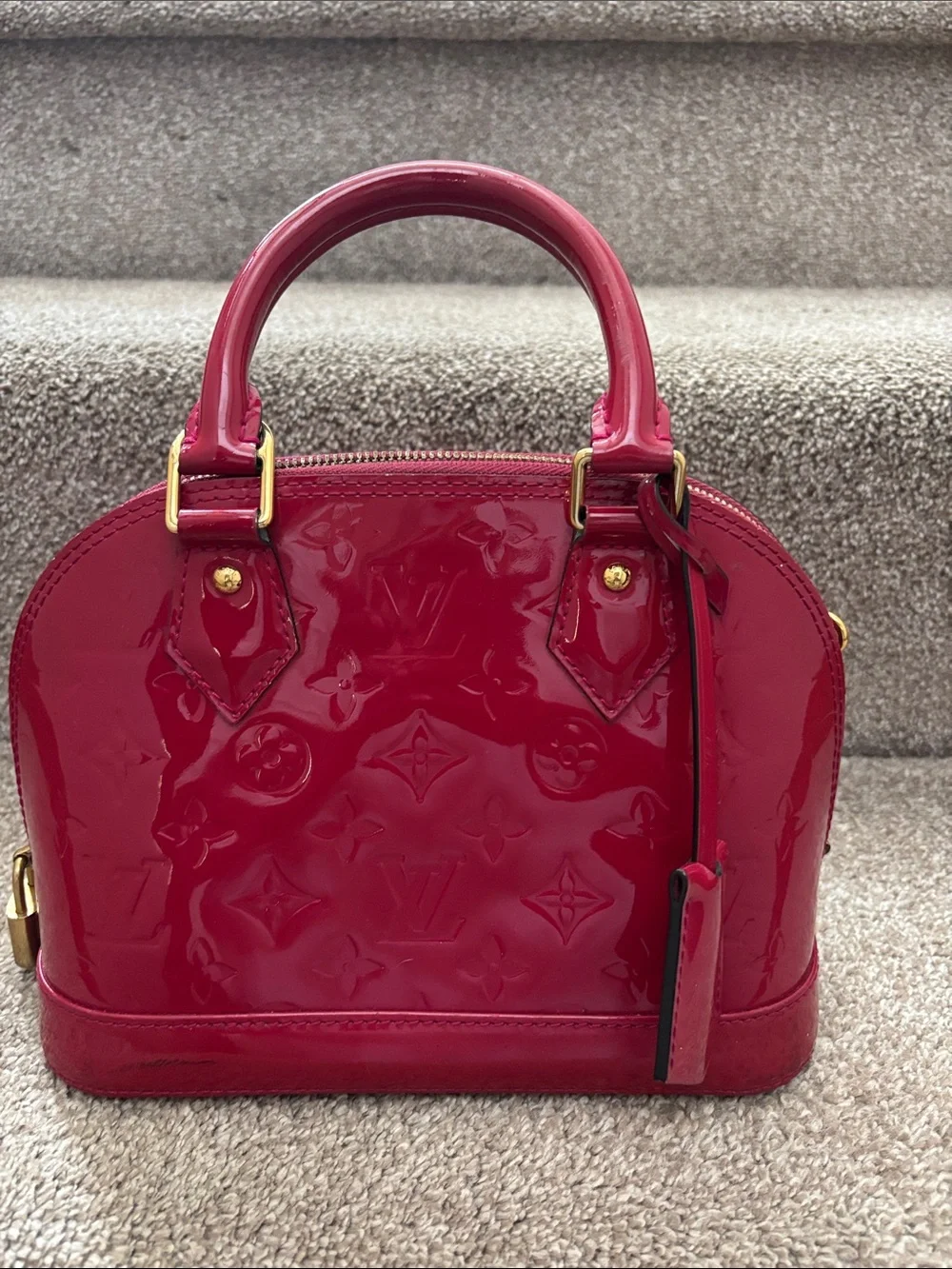 Red Louis Vuitton Alma BB crafted from glossy Monogram Vernis patent leather
